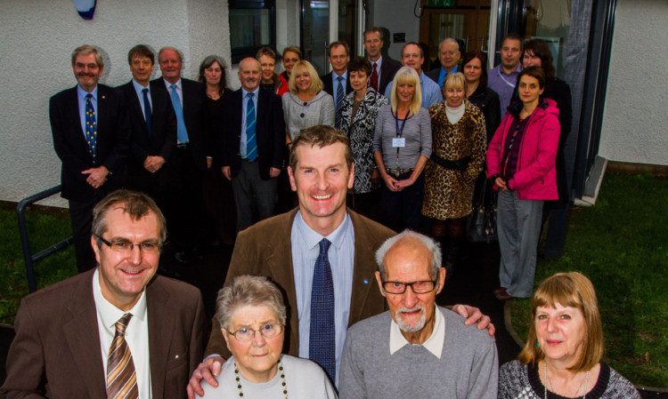 Jack Harrison and his wife, Isobel, a service user, cut the ribbon with, from left:  John Walker, Perth and Kinross Councils area director for housing and community care; Councillor Dave Doogan; and unit manager Sarah Gordon, surrounded by staff, service users, council representatives and supporters of the centre.