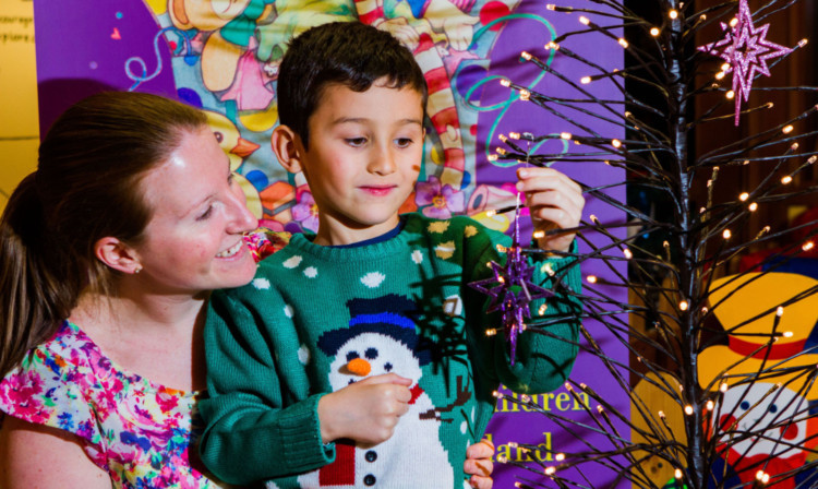 Eve and Logan McRae add the first sparkles to the Lost Christmas Tree.