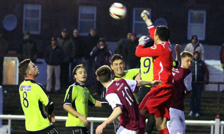 Stranraer keeper David Mitchell jumps to clear an Arbroath attack at Gayfield.