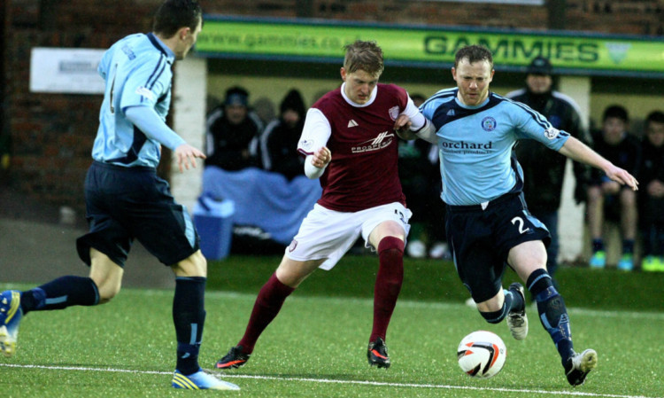 Forfar duo Mark Baxter (right) and Neil McCabe move in to challenge Arbroath goal hero Michael Travis during the rain-ravaged  Station Park derby.