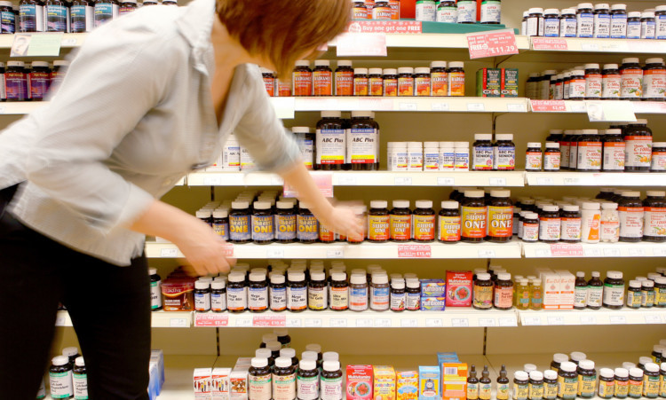 A woman picks up health supplements in a high street shop.