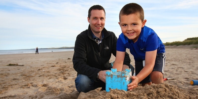 Kris Miller, Courier, 26/09/11. Picture today on West Sands, St Andrews shows Fraser Simpson and son Callum Martin who were prepared for the good weather heading our way. Pic shows Fraser and Callum enjoying the start of the good weather.