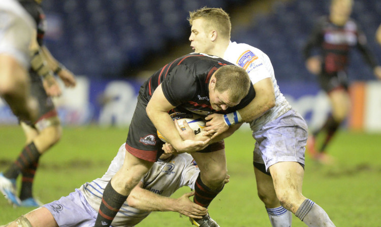 Edinburghs Willem Nel powers on despite the efforts of Leinsters Ian Madigan and a team-mate.