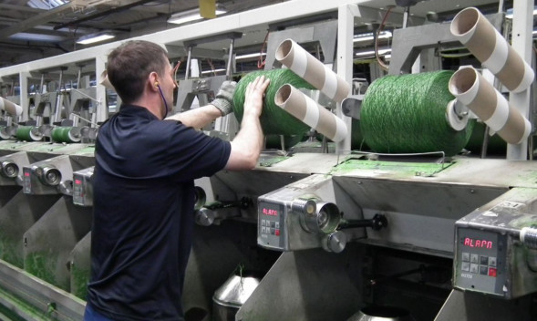 A worker overseeing synthetic grass textile production at Low & Bonars Caldrum Street works in Dundee.