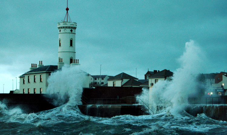 Waves crash over the sea wall between the lifeboat station and the Signal Tower Museum in Arbroath on Friday.