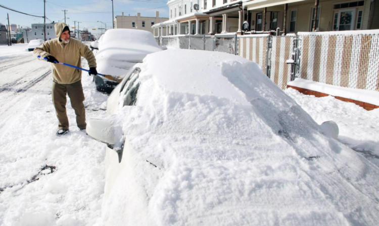 Gary Warrington digs his car out following heavy snowfall in Atlantic City, New Jersey.