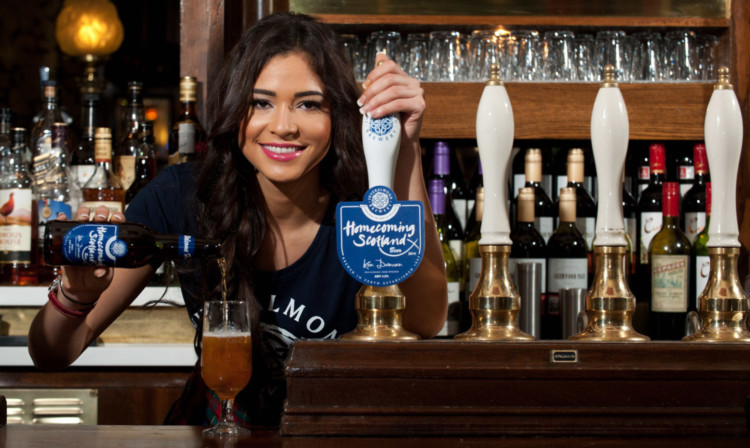 Miss Scotland Jamey Bowers pours a bottle of Inveralmond's Homecoming Scotland Beer.