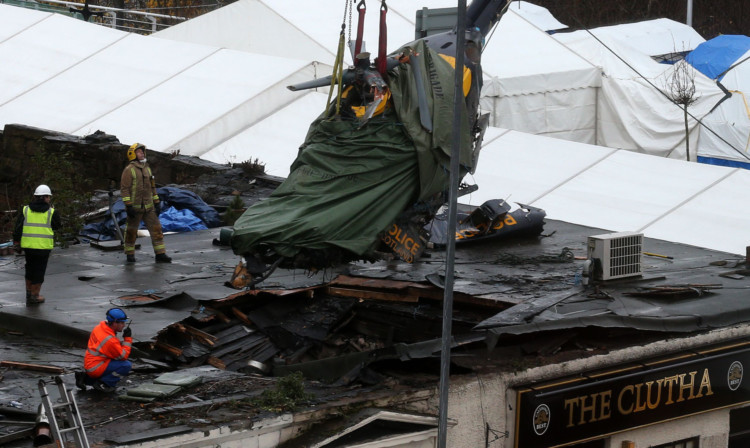 The wreckage of the police helicopter being removed from The Clutha's roof in December.