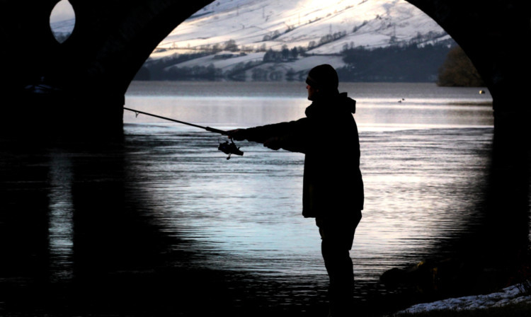 A Fisherman casts his line into the river Tay at Kenmore.