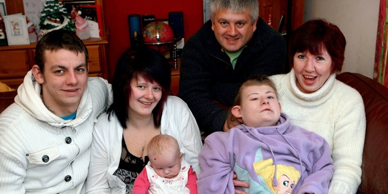 Bob Douglas, Evening Telegraph. Leah Johnstone home for Christmas from Rachel House after being snowed in last week for ten days. L-r, Leah's brother, David with partner, Danielle Mackie and three-month-old Katelynn, Leah's dad, David Johnstone, Leah and Leah's mum, Kim Johnstone pictured at home, 40 Cowbakie Crescent, Leuchars. ALL NAMES AND ADDRESS CORRECT.