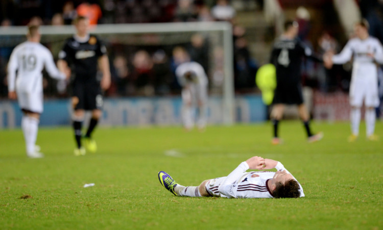 Jordan McGhee cuts a dejected figure at full time as Hearts suffer defeat to Motherwell.