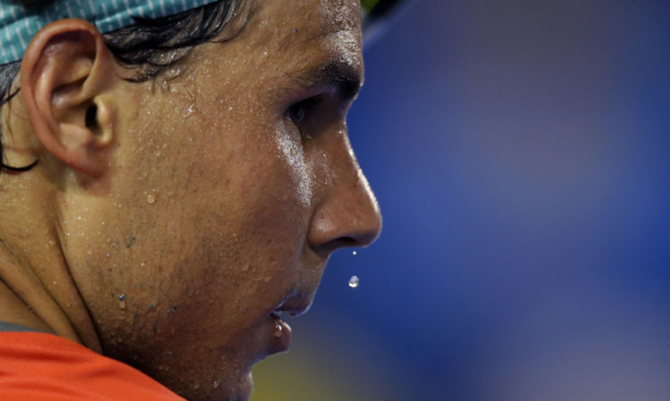 Rafael Nadal progressed in Melbourne after Bernard Tomic retired with an injury.