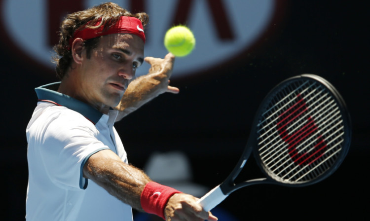 Roger Federer makes a backhand return to James Duckworth during their first round match at the Australian Open.