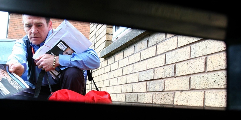 Postman Allan Morrison delivers Swine Flu leaflets in the Maryhill area of Glasgow.