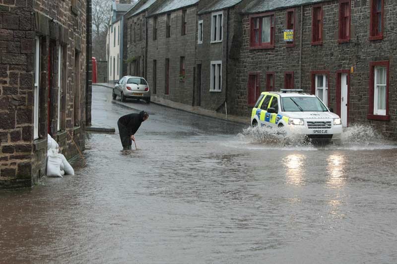 Kim Cessford, Courier - 29.11.11- pictured is Muthill resident Derek Robertson who was rodding the drains outside his house in the centre of the town in an effort to stop the flood water