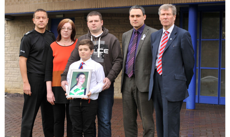 Chief Superintendent Garry McEwan, Mary Stark, David Stark with 12-year-old Liam Stark holding a picture of his murdered uncle, Sean Stark, Councillor Kenny Selbie and Mr MacAskill.