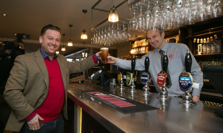Tom from Beaconsfield buys the first pint from shift manager Derek at the Hope And Champion.