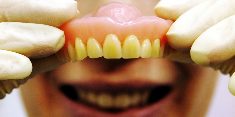 A dental nurse holds some false teeth.