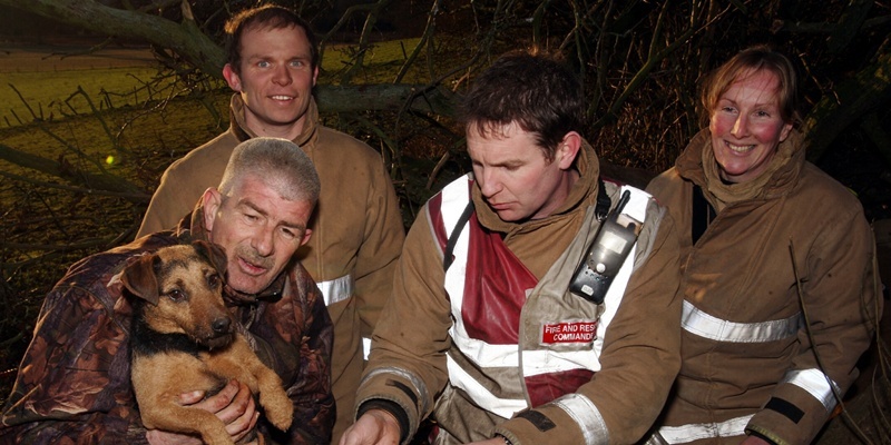 John Stevenson. Courier. 22/01/12. Dundee. Dog rescued from rabbit burrow by fire fighters. Pic shows owner Ged Kennedy reunited with Tig after spending 26 hours trapped underground with the rescue team l/r Johnny Robinson, crew manager Mark Low and Karen Goodwin..