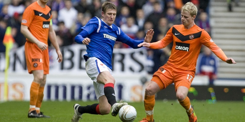 Rangers' Dorin Goian (M) challenges Dundee United's Gary Mackay-Steven