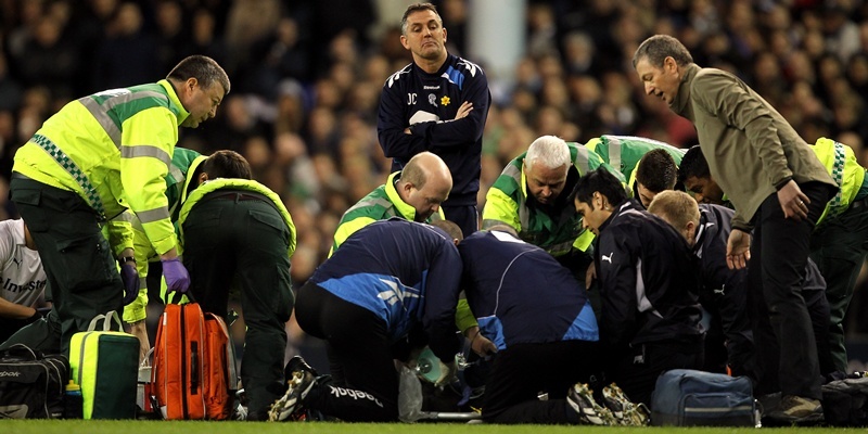 Bolton Wanderers' manager Owen Coyle look on as Fabrice Muamba is treated on the pitch after collapsing by medical staff and dr. Andrew Deaner (right)