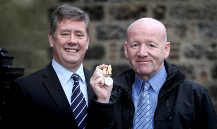 Keith Brown MSP presents Iraq Veteran, John Gardiner with his Iraq service medal.