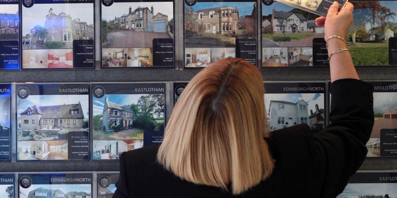 File photo dated 17/02/09 of a woman looking at houses for sale in an estate agents in Edinburgh. Mortgage costs for first-time buyers increased for the first time in nearly a year during February, figures showed today.