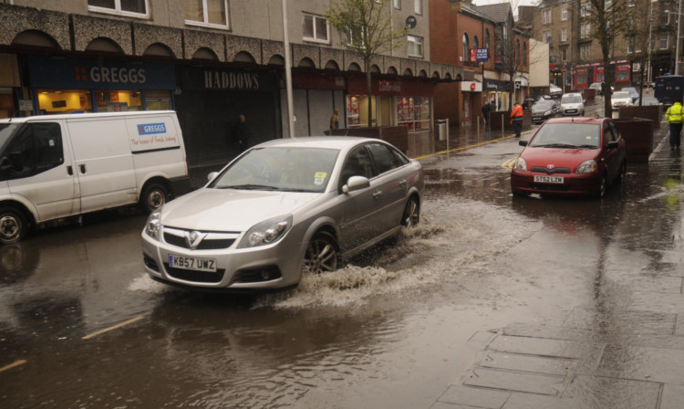 Pedestrians and vehicles were having to negotiate flooded Lochee High Street.