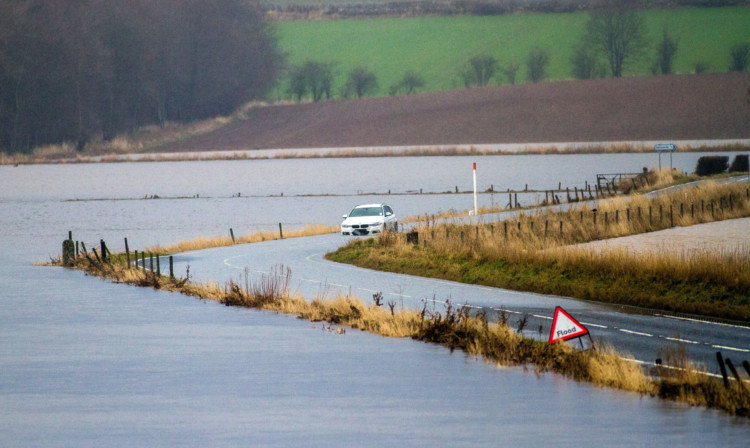 A car stuck on the B954 between Meigle and Alyth after the River Isla burst its banks and flooded the road.