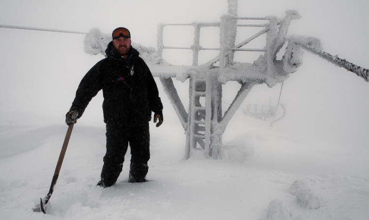 Graeme Davidson of the Glenshee ski patrol tries to dig out the chairlift at the top of the Tiger.