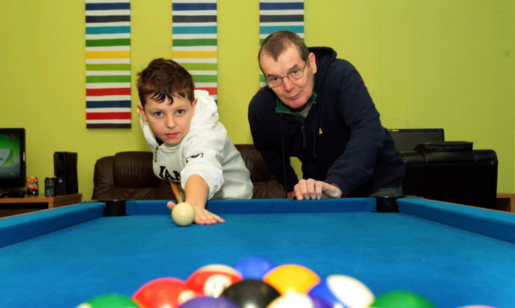 Brennan Ness and Jim Milne enjoy a game of pool.