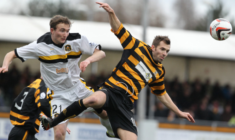 Chris Kane, left, clears the ball under pressure from Alloas Graeme Holmes at Recreation Park.