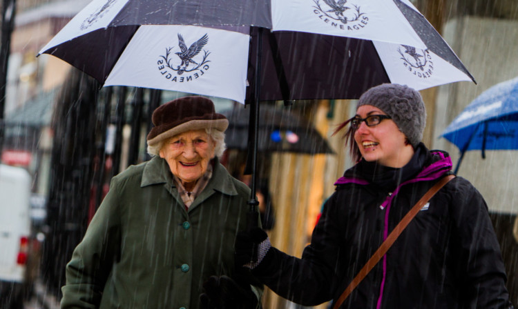 Courier reporter Sandra Gray does her bit by sheltering Fay Robertson from the rain in Pitlochry.