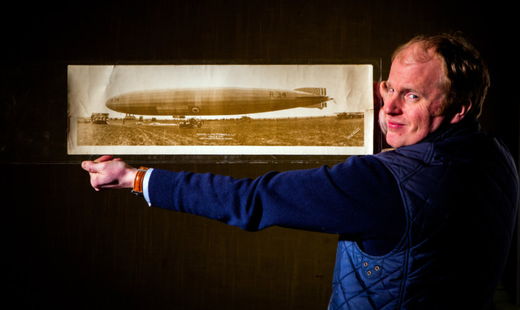 Auctioneer Nick Burns shows the airship, which was reported for sale in The Courier.