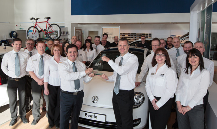 Barnetts Volkswagen managing director Jim Brown, centre left, and chairman Paul Barnett proudly show off the award for Best Dealership surrounded by the team whose focus on customer service won it.
