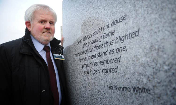 Ian Nimmo White at the memorial, which is inscribed with a poem he wrote in tribute to the disaster victims.