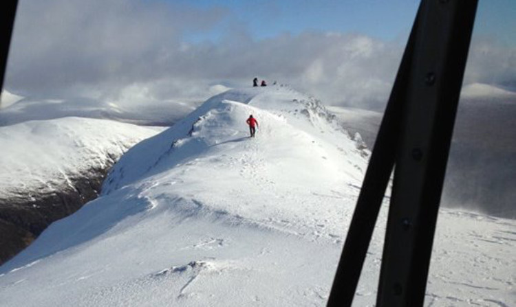 A photo taken from the helicopter shows Lt/Cdr Suckling battling across the snow to reach the stricken climbers.