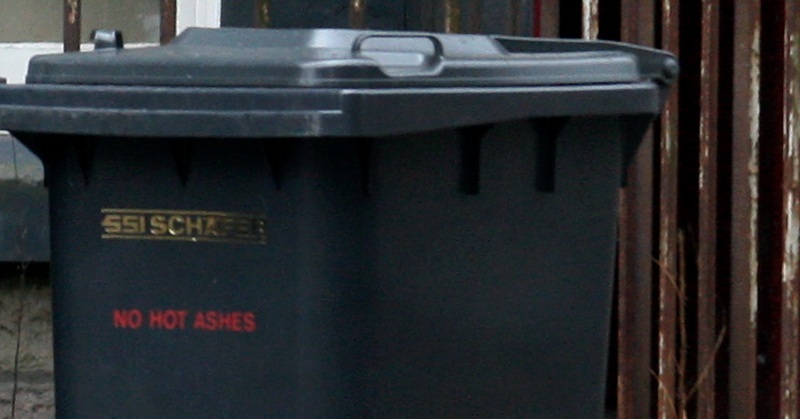 A bin outside a city flat filled more in hope than expectation of it being emptied.   A full wheelie bin, Dundee.