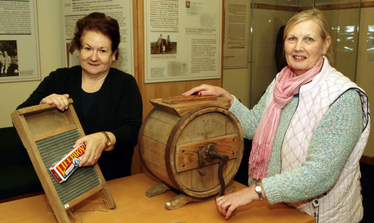Centre assistant Elizabeth McKay with a washboard and manager Isabella Williamson with a butter churn.