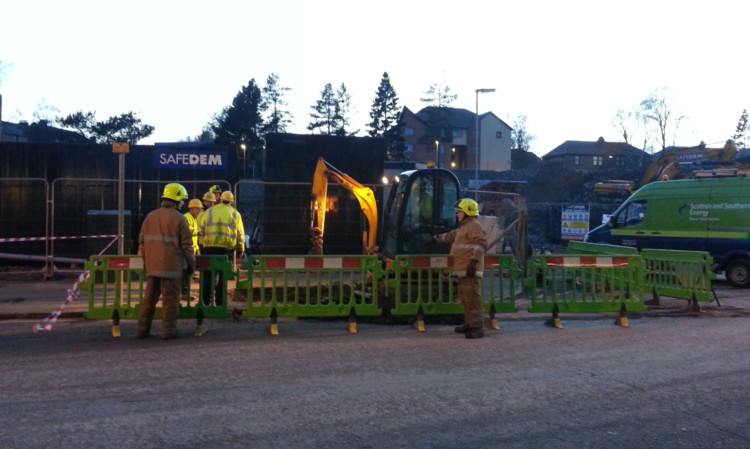 Firefighters and Scottish and Southern Energy engineers dealing with the underground electrical fault to make the area safe.
