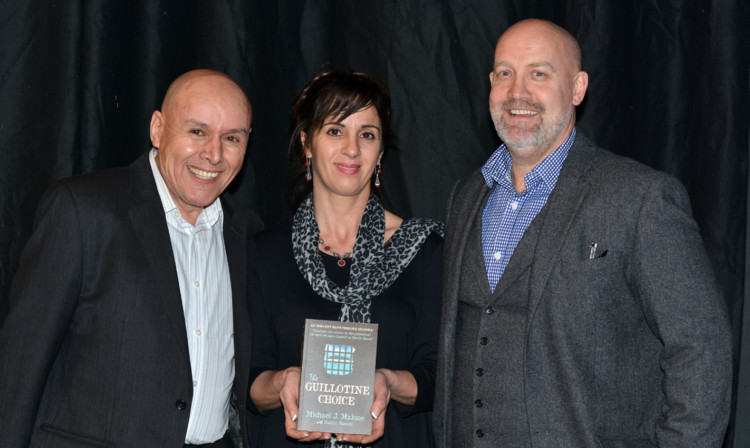 Bashir Saoudi and his wife Samia holding The Guillotine Choice by Michael J Malone (right).