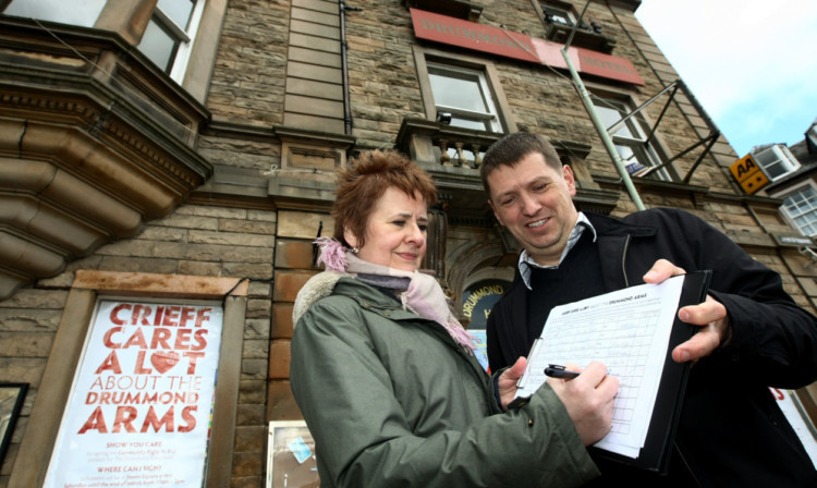 Roseanna Cunningham MSP signing the petition at the Drummond Arms with Barry Hargrave, coordinator of the town centre group.