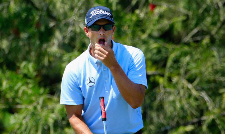 Leader Adam Scott reacts to a missed putt for birdie on the second hole.