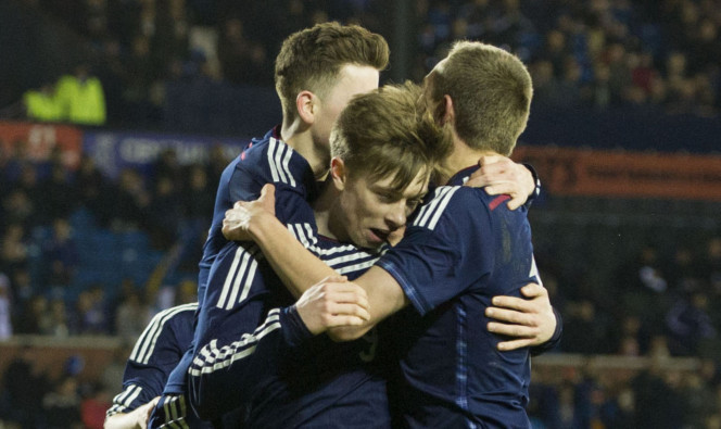 Craig Wighton, centre, is mobbed by his team mates after adding Scotlands second goal of the game.
