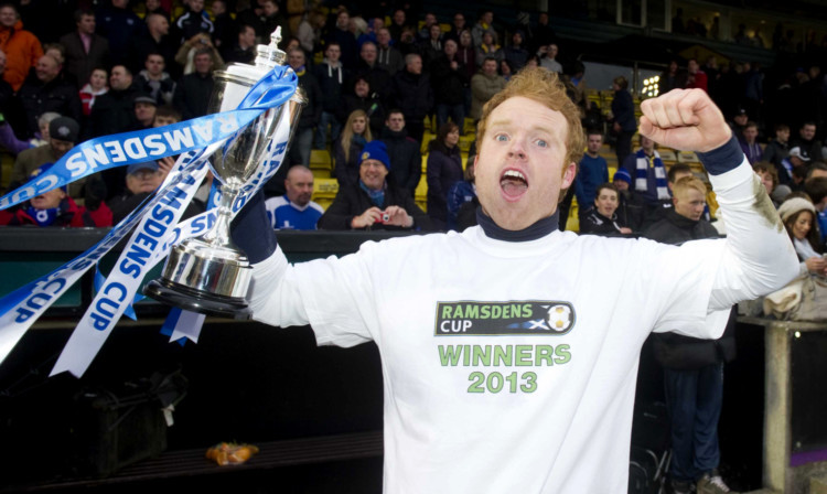 Lee Robinson celebrates winning the cup with Queen of the South last year.