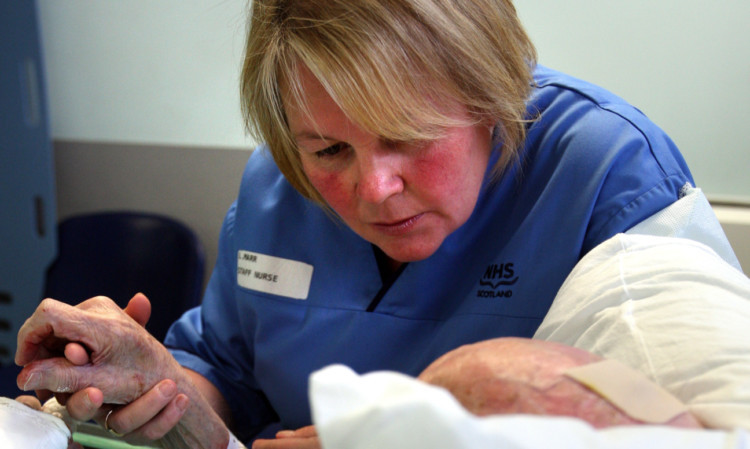 Nurse Lynn Marr talking to an elderly patient in A&E.