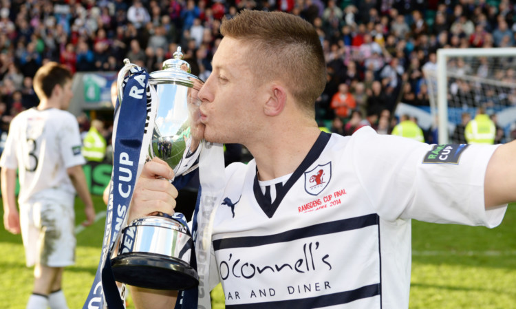 Raith goal hero John Baird plants a kiss on the Ramsdens Cup trophy.