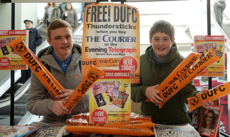 Cameron McDonald and Mark Flynn pick up their thundersticks at the merchandising stall in the Wellgate, Dundee.