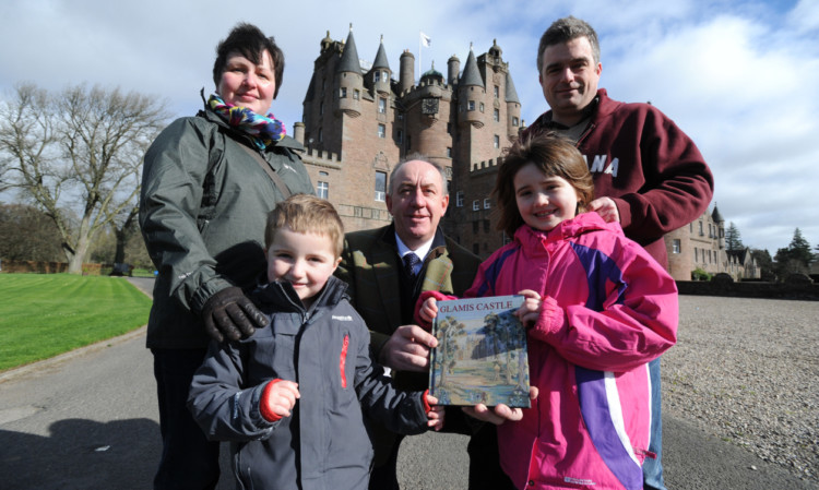 Mr Mardall presents the Keilty family   parents Garry and Elaine and children Fraser and Anna  with a Glamis Castle history book to mark them being the first visitors of the new summer season.