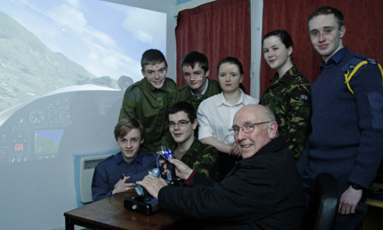 Bill McLaren at the controls of the simulator surrounded by squadron members.
